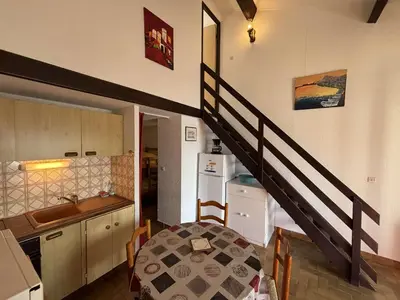 a kitchen with a staircase leading up to a living room at Maison deux pièces cabine PORT LA NOUVELLE PN370-026 in Port-la-Nouvelle