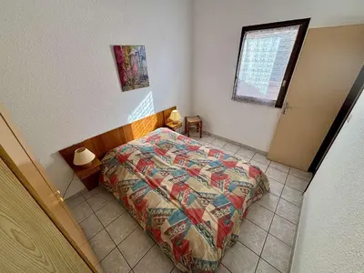 a bedroom with a bed with a quilt on it at Maison deux pièces cabine PORT LA NOUVELLE PN370-026 in Port-la-Nouvelle