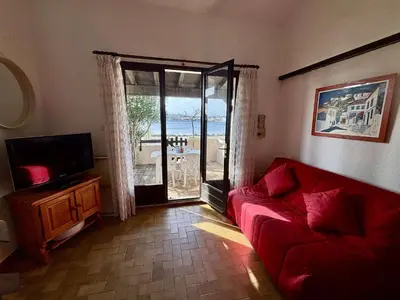 a living room with a red couch and a sliding glass door at Maison deux pièces cabine PORT LA NOUVELLE PN370-026 in Port-la-Nouvelle