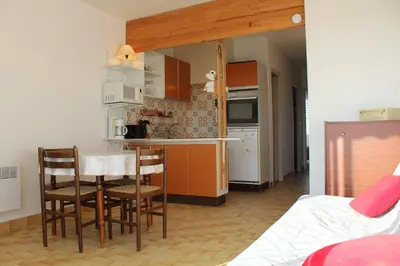 a kitchen with a table and chairs in a room at Appartement 2 pièces PORT LA NOUVELLE PN440-024 in Port-la-Nouvelle