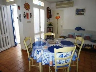 a dining room table with chairs and a blue and white table cloth at Maison 3 pièces PORT LA NOUVELLE PN500-005 in Port-la-Nouvelle