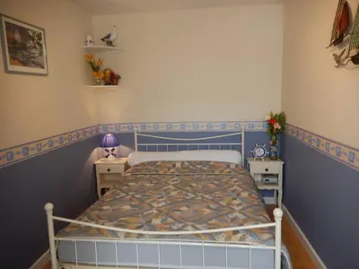 a bedroom with a bed with a blue and white bedspread at Maison 3 pièces PORT LA NOUVELLE PN500-005 in Port-la-Nouvelle