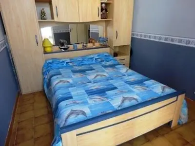 a bedroom with a bed with a blue comforter at Maison 3 pièces PORT LA NOUVELLE PN500-005 in Port-la-Nouvelle