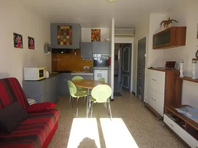 a living room with a couch and a table in a kitchen at Appartement 2 pièces PORT LA NOUVELLE PN520-031 in Port-la-Nouvelle