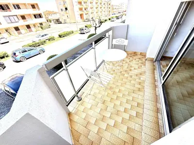 a balcony with a table and a view of a street at Appartement 3 pièces Port-la-Nouvelle PN550-012 in Port-la-Nouvelle
