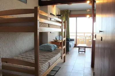 a bedroom with two bunk beds and a living room at Appartement 2 pièces PORT LA NOUVELLE PN590-033 in Port-la-Nouvelle
