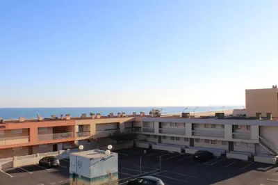 a view of a building with the ocean in the background at Appartement 2 pièces PORT LA NOUVELLE PN590-033 in Port-la-Nouvelle