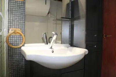 a white sink in a bathroom with a mirror at Appartement 2 pièces PORT LA NOUVELLE PN590-033 in Port-la-Nouvelle