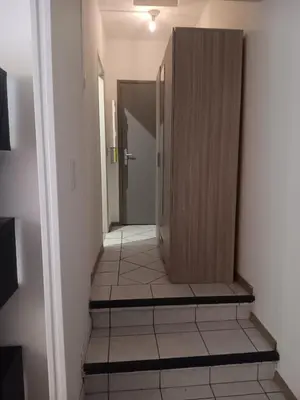 a hallway with a wooden door and a tile floor at Studio in Lézignan-Corbières