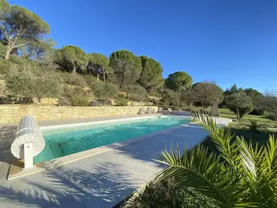 a swimming pool in the middle of a yard with trees at Magnifique villa dans le massif de la Clape in Armissan