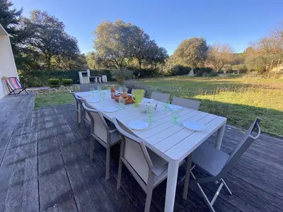 a white table and chairs on a wooden deck at Magnifique villa dans le massif de la Clape in Armissan
