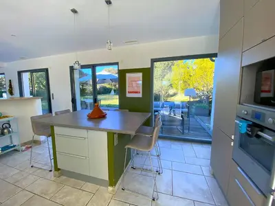 a kitchen with a counter with stools in it at Magnifique villa dans le massif de la Clape in Armissan