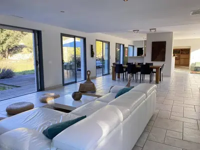 a living room with a white couch and a table at Magnifique villa dans le massif de la Clape in Armissan