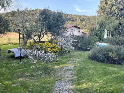 a garden with a house and a bench in the grass at l escapade Corbières in Lagrasse