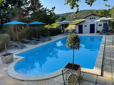 a swimming pool with chairs and umbrellas at l escapade Corbières in Lagrasse