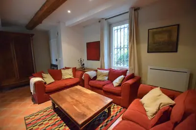a living room with red couches and a table at l escapade Corbières in Lagrasse