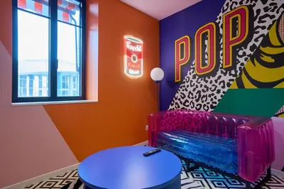 a colorful room with a bench and a pop sign at La Villa Orange - POP'ART - proche cité médiévale et centre ville à pied in Carcassonne