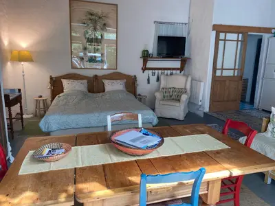 a living room with a table and a bed at Mas Vigneron in Puicheric