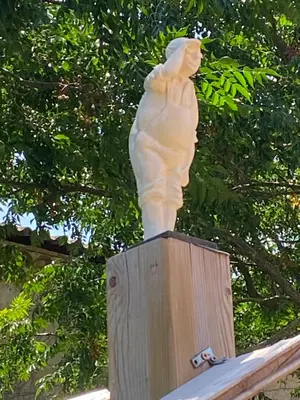 a statue of a woman sitting on a wooden post at Mas Vigneron in Puicheric