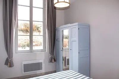 a bedroom with a blue cabinet and two windows at Le Nayrac l Hypercentre l Parking privé in Castres