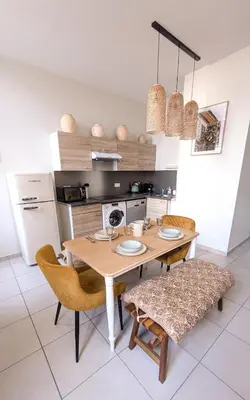 a kitchen with a table and chairs and a kitchen with a refrigerator at Le Nayrac l Hypercentre l Parking privé in Castres