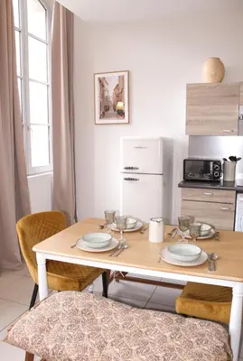 a kitchen with a wooden table with plates on it at Le Nayrac l Hypercentre l Parking privé in Castres