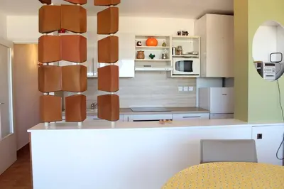 a kitchen with white cabinets and a counter top at Appartement 3 pièces PORT LA NOUVELLE PN210-064 in Port-la-Nouvelle
