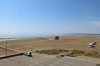 a parking lot with cars parked in a parking lot next to the ocean at Appartement 3 pièces PORT LA NOUVELLE PN210-064 in Port-la-Nouvelle