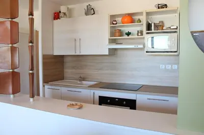a kitchen with white cabinets and a stove top oven at Appartement 3 pièces PORT LA NOUVELLE PN210-064 in Port-la-Nouvelle