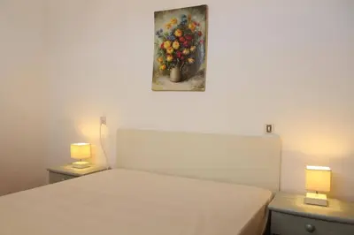 a bedroom with a bed with a painting on the wall at Appartement 3 pièces PORT LA NOUVELLE PN210-064 in Port-la-Nouvelle