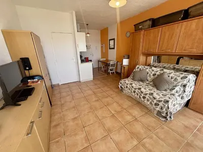 a living room with a couch and a large window at Appartement 2 pièces PORT LA NOUVELLE PN430-027 in Port-la-Nouvelle