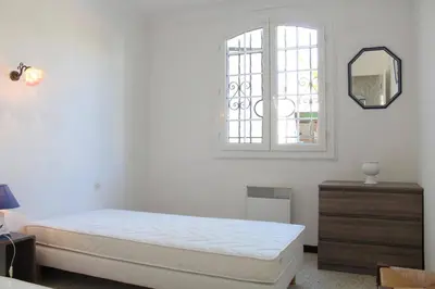 a white bedroom with a bed and a window at Maison 3 pièces PORT LA NOUVELLE PN000-156 in Port-la-Nouvelle