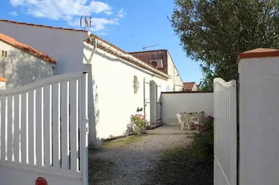 a white fence next to a white house at Maison 3 pièces PORT LA NOUVELLE PN000-156 in Port-la-Nouvelle