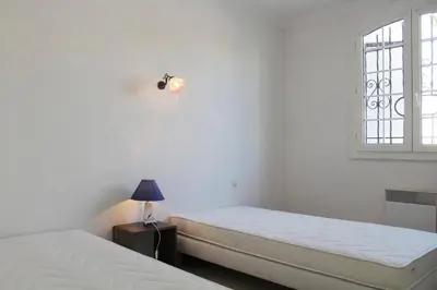a white room with two beds and a window at Maison 3 pièces PORT LA NOUVELLE PN000-156 in Port-la-Nouvelle