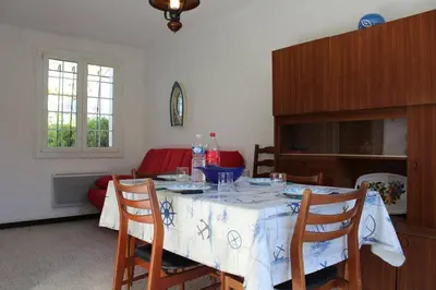 a dining room with a table with chairs and a tableablish at Maison 3 pièces PORT LA NOUVELLE PN000-156 in Port-la-Nouvelle