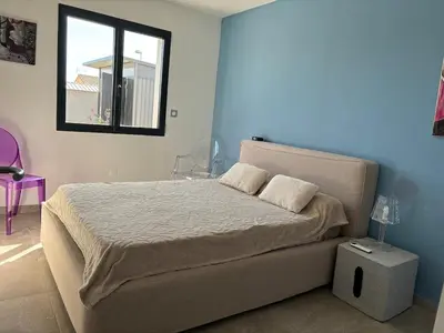 a bedroom with a bed and a window at La Maison Laurier in Lézignan-Corbières