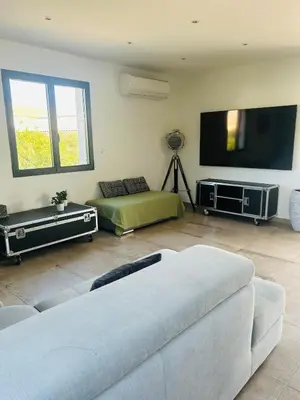 a living room with a couch and a flat screen tv at La Maison Laurier in Lézignan-Corbières