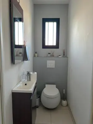 a white bathroom with a toilet and a sink at La Maison Laurier in Lézignan-Corbières