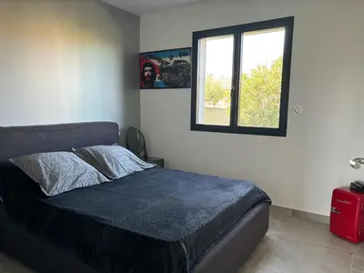 a bedroom with a bed and a window at La Maison Laurier in Lézignan-Corbières