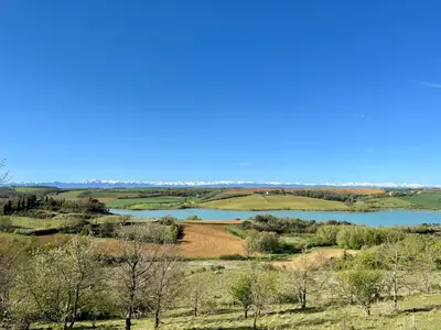 a view of a large lake in a field at La bergerie - Paisible vue lac et montagne in Molleville