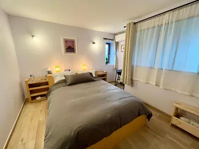 a bedroom with a large bed and a window at La bergerie - Paisible vue lac et montagne in Molleville