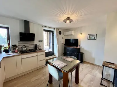 a living room with a table and a kitchen at La bergerie - Paisible vue lac et montagne in Molleville