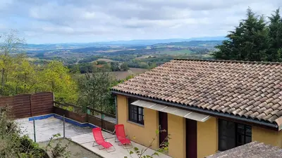 a house with two red chairs in front of it at L'Orchidée chambres d'hôtes in Hounoux