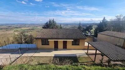 a small house sitting on top of a hill at L'Orchidée chambres d'hôtes in Hounoux