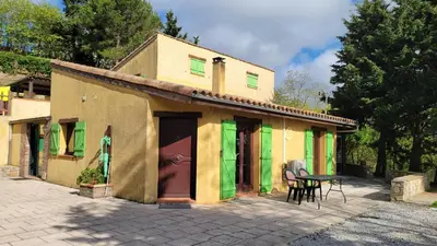 a small building with colorful doors and a table at L'Orchidée chambres d'hôtes in Hounoux