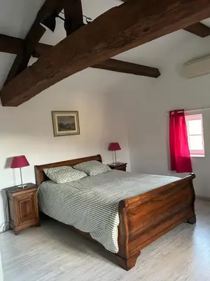 a bedroom with a wooden bed and two lamps at Aux portes du Sidobre in Noailhac