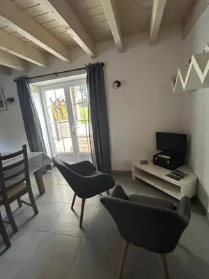 a living room with chairs and a tv and a window at Aux portes du Sidobre in Noailhac