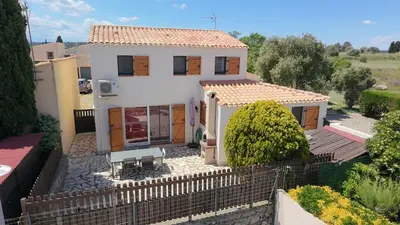 a white house with a fence in front of it at Gruissan Maison familiale 2 à 6 personnes - 3 chambres et 2 SDB ! in Gruissan