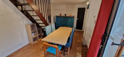 a table and chairs in a room with a staircase at Gruissan Maison familiale 2 à 6 personnes - 3 chambres et 2 SDB ! in Gruissan