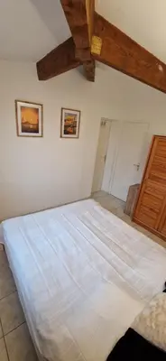 a large bed in a bedroom with wooden ceilings at Gruissan Maison familiale 2 à 6 personnes - 3 chambres et 2 SDB ! in Gruissan